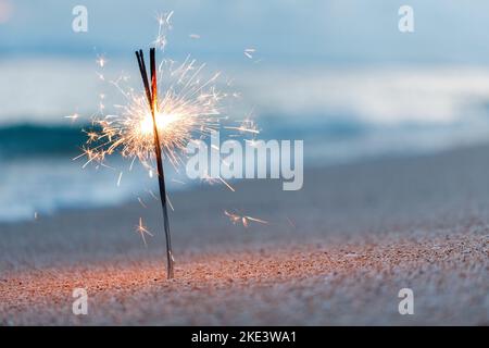 Bengalische Lichter am Strand in der Nähe des Ozeans Stockfoto