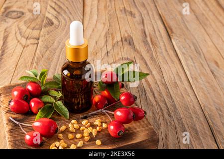 Kosmetikflasche mit Tropfflasche aus dunklem Glas mit einem Bio-Produkt auf Basis von Hagebuttenkernöl. Naturkosmetik. Produktpräsentation Stockfoto