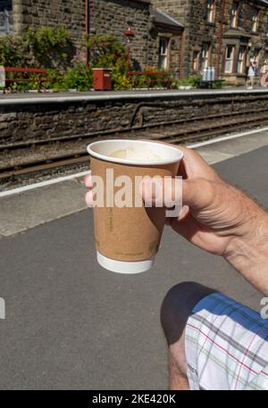 Nahaufnahme der Hand Person, die trinkt biologisch abbaubar kompostierbare Getränk Getränke Tasse aus Pflanzen England Großbritannien hergestellt Stockfoto