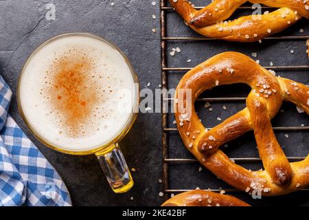 Frisch gebackene hausgemachte Brezeln und Bier vom Fass. Flach liegend Stockfoto