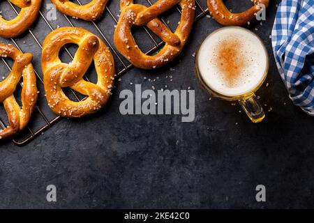 Frisch gebackene hausgemachte Brezeln und Bier vom Fass. Flach liegend mit Kopierplatz Stockfoto