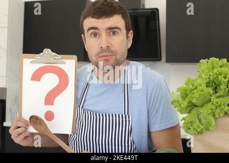 Mann mit Fragezeichen in der Küche Stockfoto