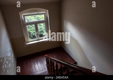 Das Innere einer Holztreppe in einem alten Wohnhaus. Foto aufgenommen bei Tageslicht. Stockfoto