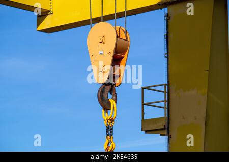 Portalkran mit Haken gegen blauen Himmel. Baustelle Stockfoto