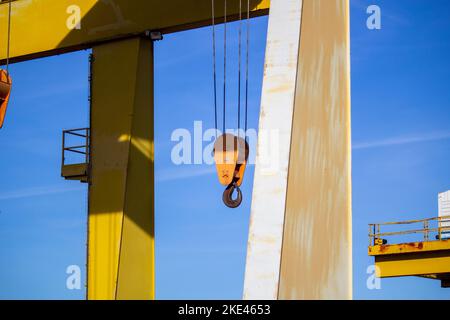 Portalkran mit Haken gegen blauen Himmel. Baustelle Stockfoto