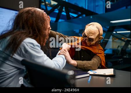 Zombie-Geschäftsleute kämpfen in Firmenbüros Stockfoto