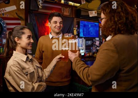 Fröhliche, vielfältige Freunde, die mit Bier anstoßen Stockfoto