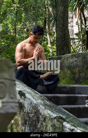 Ein Mann ohne Hemd dehnt sich auf der Yogamatte in Mexiko, Lateinamerika Stockfoto