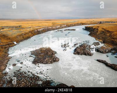 Hellblauer Fluss durch das Island Festland im Herbst an einem kalten bewölkten Tag Stockfoto