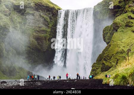 Berühmter Skogafoss Wasserfall am Skoga Fluss mit Massen von Touristen darunter Stockfoto