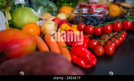 Eine selektive Aufnahme von frischem Obst und Gemüse auf einem Holztisch Stockfoto