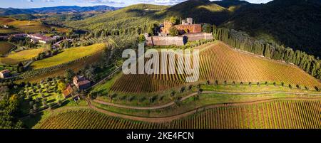 Italien, Landschaft der Toskana. Luftdrohne Panoramablick auf schöne mittelalterliche Burg Castello di Brolio in Chianti-Region von goldenen Herbst umgeben Stockfoto