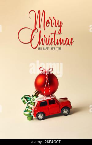 Kleines rotes Spielzeugauto und roter Weihnachtsball auf hellem Hintergrund Stockfoto