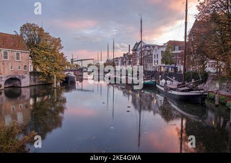 Rotterdam, Niederlande, 4. November 2022: Der Aelbrechtskolk-Kanal im Delfshaven-Viertel bei Sonnenuntergang unter einem bunten Himmel Stockfoto