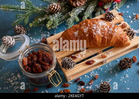 Croissant-Nahaufnahme auf Tafel, Weihnachtskomposition. Stockfoto