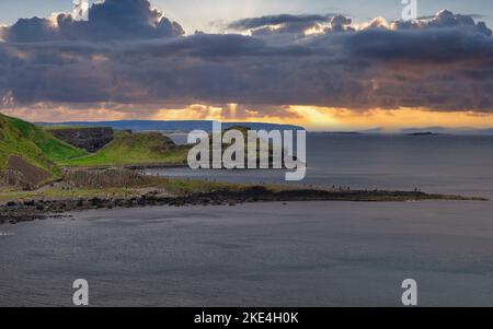 Touristen klettern auf den uralten Basaltsäulen des Giant's Causeway UNESCO-Weltkulturerbes, Causeway Coast, County Antrim, Nordirland Stockfoto