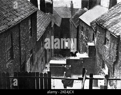 Slum-Innenhof in der nördlichen Industriestadt, England, 1933. Die Slum-Räumung im Vereinigten Königreich wurde als Strategie für die Stadterneuerung genutzt, um ärmere Gebiete umzugestalten. In den nördlichen Städten des Landes fanden frühzeitige Massenfreigaben statt. Ab den 1930er Jahren, mit dem Wohnungsgesetz 1930, wurde von den Räten erwartet, dass sie Pläne für die Räumung von Slumwohnungen ausarbeiten, obwohl die Fortschritte nach Beginn des Zweiten Weltkriegs zum Stillstand kamen Stockfoto