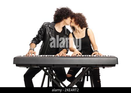 Junge Männer und Frauen spielen ein digitales Klavier und küssen sich isoliert auf weißem Hintergrund Stockfoto