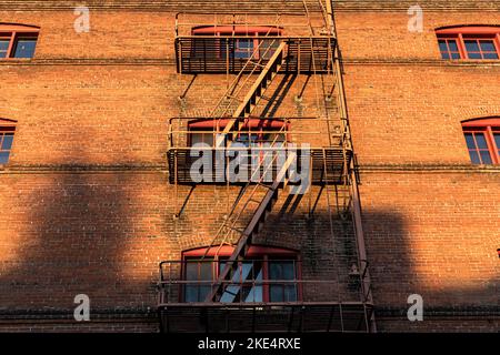 Portland, OR, USA - 16. Okt 2022: Blick auf das Mehrfamilienhaus mit einer Feuertreppe. Feuer entweicht an den Fassaden von Häusern in Portland. Stre Stockfoto