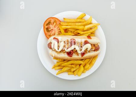 Ein Blick von oben auf einen Hot Dog mit pommes auf weißem Hintergrund Stockfoto