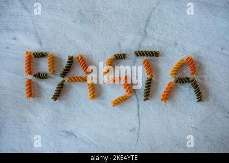 Wort Pasta in Fuselli Pasta, die dreifarbig und ungekocht ist geschrieben. Stockfoto