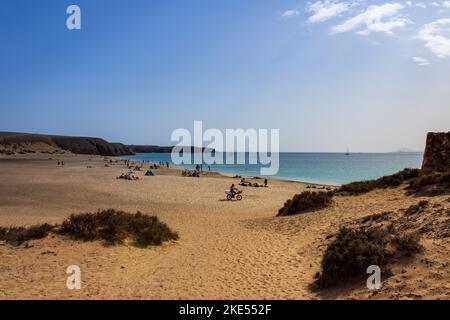 Panoramablick auf Playa Mujeres Strand mit Atlantik und umgebender trockener Landschaft an der Papagayo Küste von Playa Blanca, Lanzarote, Kanarienvogel Stockfoto