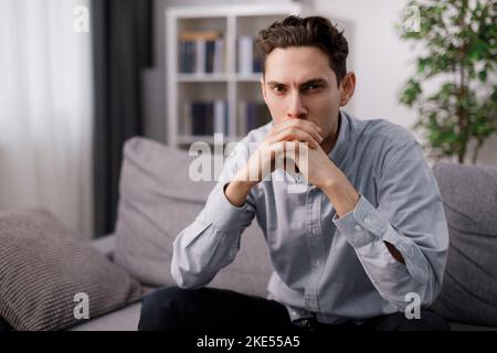 Nachdenklicher Mann auf sofa Stockfoto