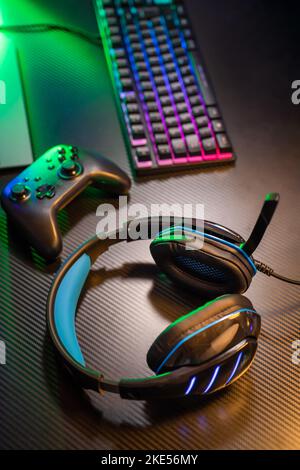 Draufsicht auf den Arbeitsplatz und die Ausrüstung des Spielers, Headset, Maus, Tastatur, Joystick, VR auf schwarzem Tisch Stockfoto