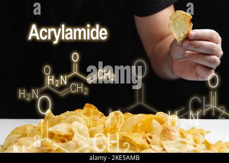 Mann isst frittierte Lebensmittel, Chips hoch in Acrylamid. Acrylamidformel auf schwarzem Hintergrund Stockfoto