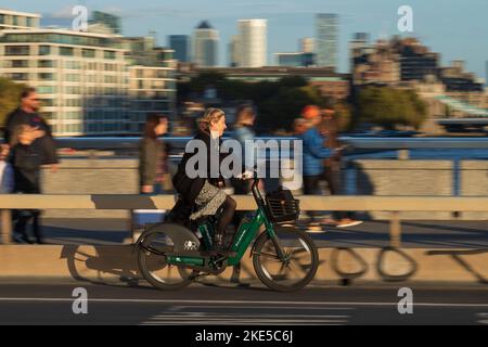 Eine Frau, die während der Hauptverkehrszeit mit einem HumanForest-Fahrrad über die London Bridge pendelt. London Bridge, London, Großbritannien. 28 Okt 2022 Stockfoto