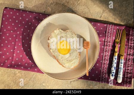 Gesundes Frühstück. Abstrakt Gebratene Eier aus Brotscheiben und Honig Stockfoto