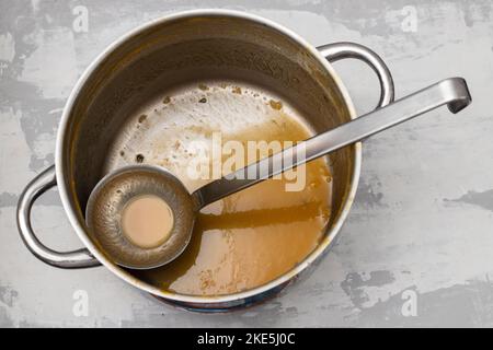 Einen Kochtopf und einen Kochlöffel nach Gebrauch für Gemüsesuppe Stockfoto