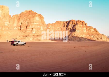 Offroad-Lastwagen oder geländewagen, die bei Sonnenuntergang in der berühmten wadi-Rum-Wüste Düne reiten. Offroad in Jordan Wadi Rum Stockfoto