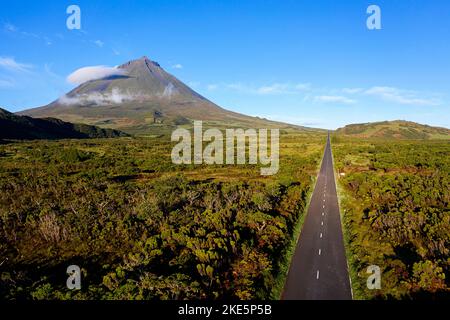 Luftaufnahme einer Straße, die Ponta da Pico teilweise mit Wolken bedeckt und klaren Himmel in der Nähe von Lagoa do Capitão, Pico Island, Azoren, Portugal Stockfoto