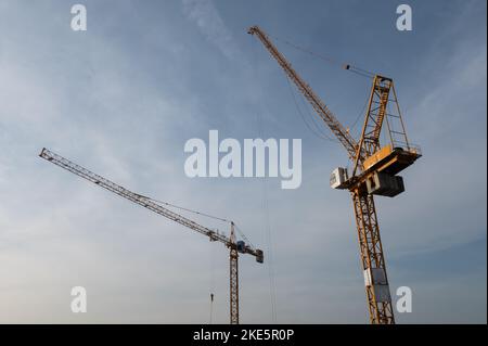 Baustelle mit zwei gelben Kränen gegen blauen Himmel Stockfoto