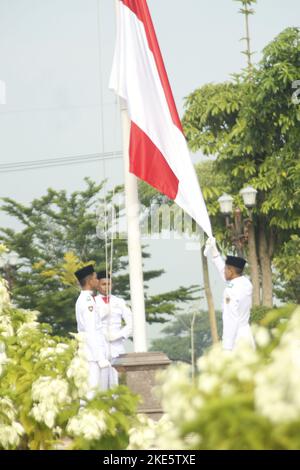 Madiun, Ost-Java, Indonesien. 10.. November 2022. Die Pusaka Flag-Raising Truppe (Paskibraka) wurde während der Gedenkfeier zum Nationalen Heldentag im Innenhof des Ronggo Djemeno Pavillons, Madiun Regency, gesehen, wie sie die rot-weiße Flagge schwenkte. Diese Gedenkfeier trug das Thema ''Mein Held, mein Beispiel' (Kreditbild: © Ajun Ally/Pacific Press via ZUMA Press Wire) Stockfoto