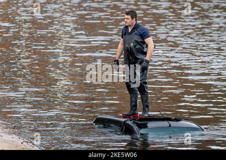 Rettungsarbeiter, der am 8. November 2022 in Stratford-upon-Avon, Warwickshire, Großbritannien, auf dem Dach eines untergetauchten Autos in den Fluss Avon gefahren ist Stockfoto