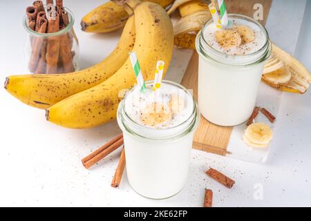 Herbst vegan Zimt Banane Smoothie, Shake oder Joghurt im Glas auf dem hellen Hintergrund. Gesunde Ernährung Stockfoto