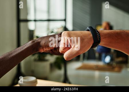 Nahaufnahme von zwei jungen interkulturellen Geschäftsleuten nach erfolgreichem Abschluss oder Unterzeichnung eines vielversprechenden Vertrags Stockfoto