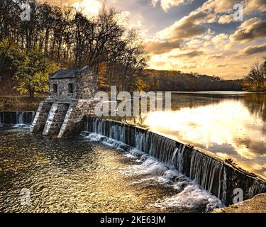 Morristown, NJ - USA - Nov 5, 2022 eine herbstliche horizontale Ansicht des historischen Speedwell-Staudamms aus Stein von New Jersey während des Sonnenuntergangs. Stockfoto