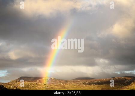 Ein dramatisches, wolkig, sonnenbeschienes, herbstliches HDR-Bild eines Regenbogens über Sutherland im Nordwesten Schottlands. 23. Oktober 2022 Stockfoto