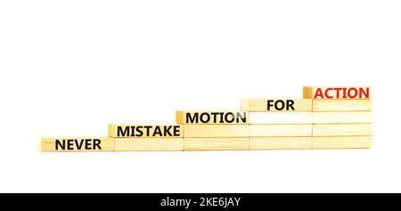 Fehler- oder Aktionssymbol. Konzeptwörter verwechseln niemals Bewegung mit Aktion auf Holzblöcken. Schöne weiße Tabelle weißen Hintergrund. Geschäftsfehler oder Stockfoto