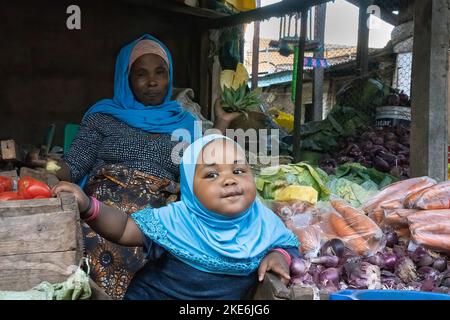 Mtowambu, Tansania - 12.. Oktober 2022: Eine Obst- und Gemüsemarktes Verkäuferin und ihre Tochter. Stockfoto