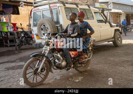 Mtowambu, Tansania - 12.. Oktober 2022: Ein Paar auf dem Motorrad in der kleinen Stadt Mtowambu, Tansania. Stockfoto