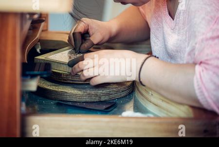 Handwerker graviert Metall und Silber, um Kunstwerke zu schaffen Stockfoto