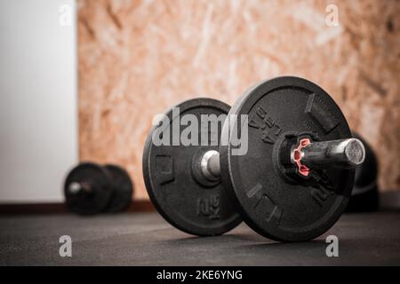 Nahaufnahme von 4,4lbs oder 2kg ladbaren Hanteln. Bodybuilding-Ausrüstung auf dem Boden im Fitnessstudio mit verschwommenem Hintergrund und leerem Platz für Text Stockfoto