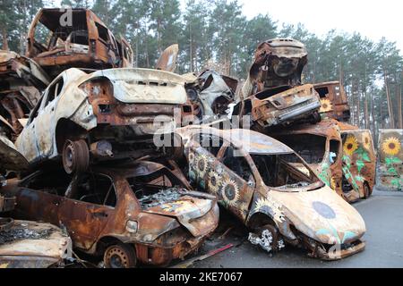 IRPIN, UKRAINE - 10. NOVEMBER 2022 - Sonnenblumen sind um die Löcher in den Autos gemalt, die von russischen Invasoren, Irpin, Kiew Region, Nord-U, zerstört wurden Stockfoto