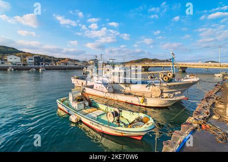 kyushu, fukuoka - dezember 08 2021: Japanische Fischerboote, ausgestattet mit Netzen und Boje, liegen im Tsuyazaki-Fischerhafen, der vom Tsuyazak durchquert wird Stockfoto