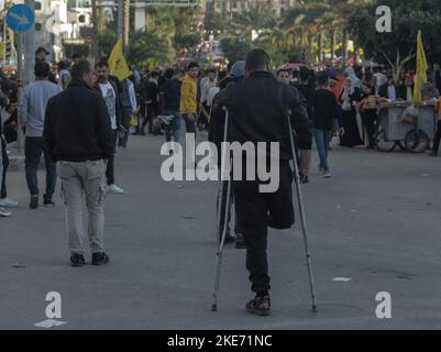 Gaza, Palästina, 10/11/2022, Ein behinderter palästinensischer Jugendlicher, der die palästinensische Fatah-Bewegung unterstützt, nimmt am 18.. Todestag des palästinensischen Präsidenten Yasser Arafat Teil. Arafat, von den Palästinensern auch Abu Ammar genannt, trug die traditionellen palästinensischen Kiffiyya- und Militärkleidung und legte eine revolutionäre Haltung ein und nahm verschiedene Wege für den palästinensischen Befreiungskampf an. Im Jahr 1994 zog Arafat nach Gaza, das von der Palästinensischen Nationalen Behörde (PNA) kontrolliert wurde – der vorläufigen Einheit, die durch die Oslo-Abkommen geschaffen wurde. Die Ursache für Arafats Tod hat Stockfoto