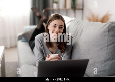 Frau mit Laptop auf sofa Stockfoto